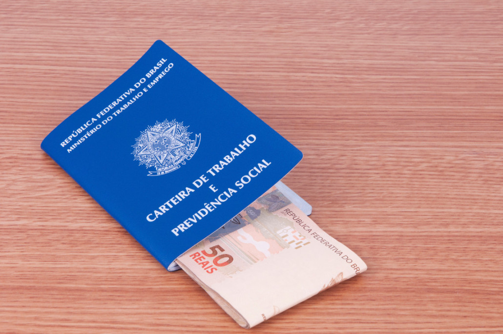 carteira de trabalho com cédulas de dinheiro dentro: dissídio é usado como sinônimo de reajuste e data-base